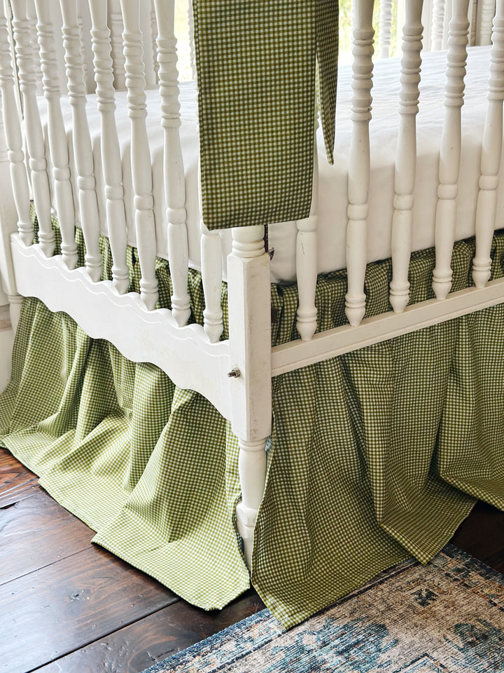 Split corner and gathered pleats of the pine green gingham farmhouse crib skirt
