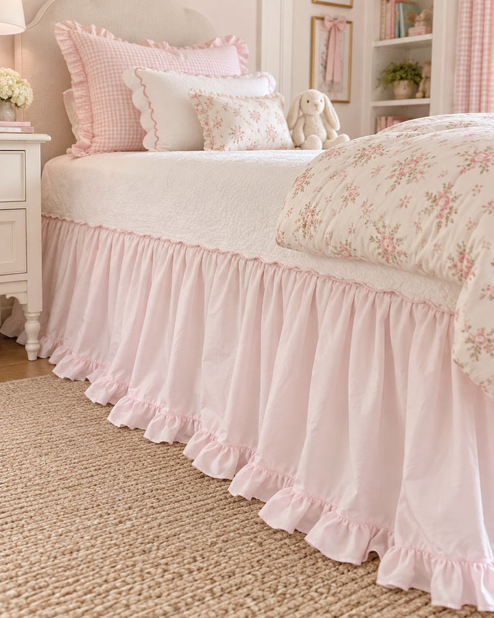 Side view of the deep gathers on a baby pink washed cotton twin bed skirt above a jute rug - High Cotton Textile
