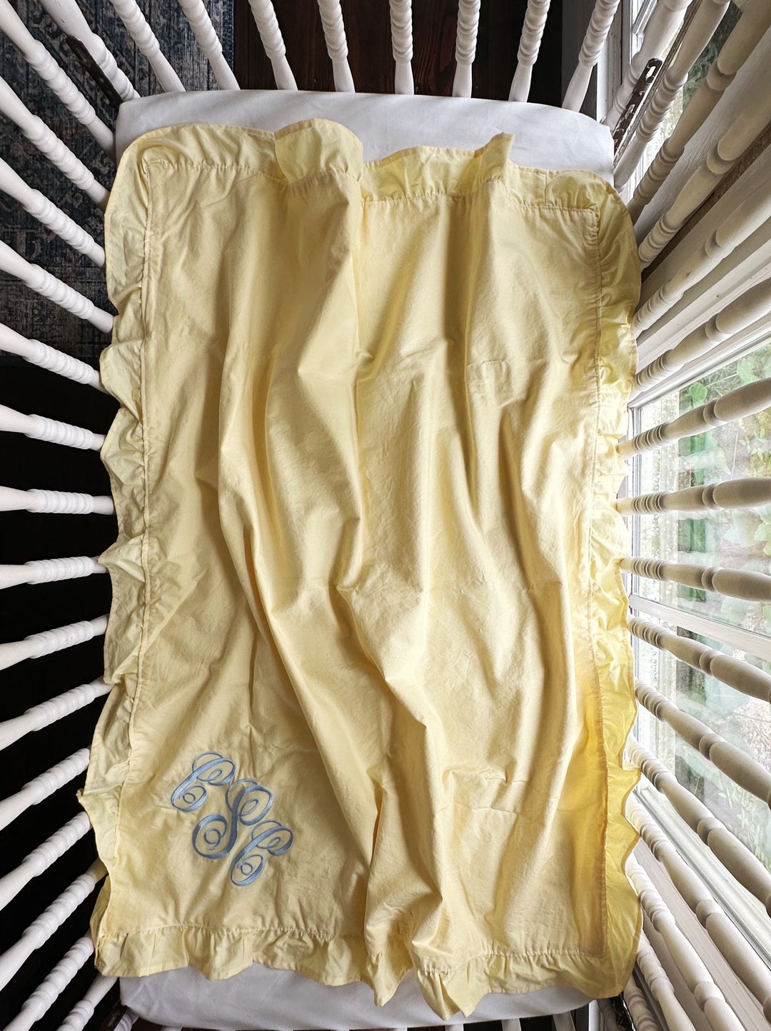 Baby yellow ruffled baby blanket laid flat showing the hemmed cotton ruffle on all four sides - High Cotton Textile