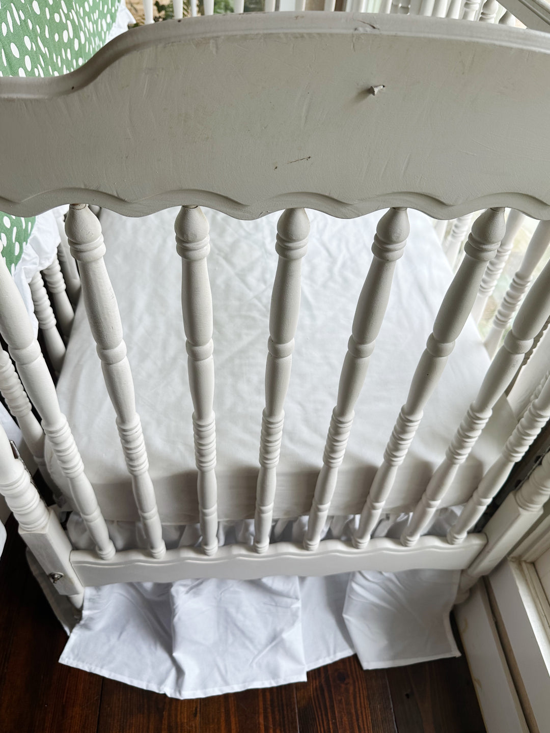Foot of the crib with the white farmhouse skirt at a 20-inch drop