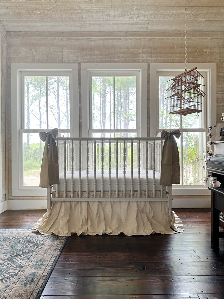 Large oatmeal crib bow paired with a natural osnaburg ruffled crib skirt - High Cotton Textile