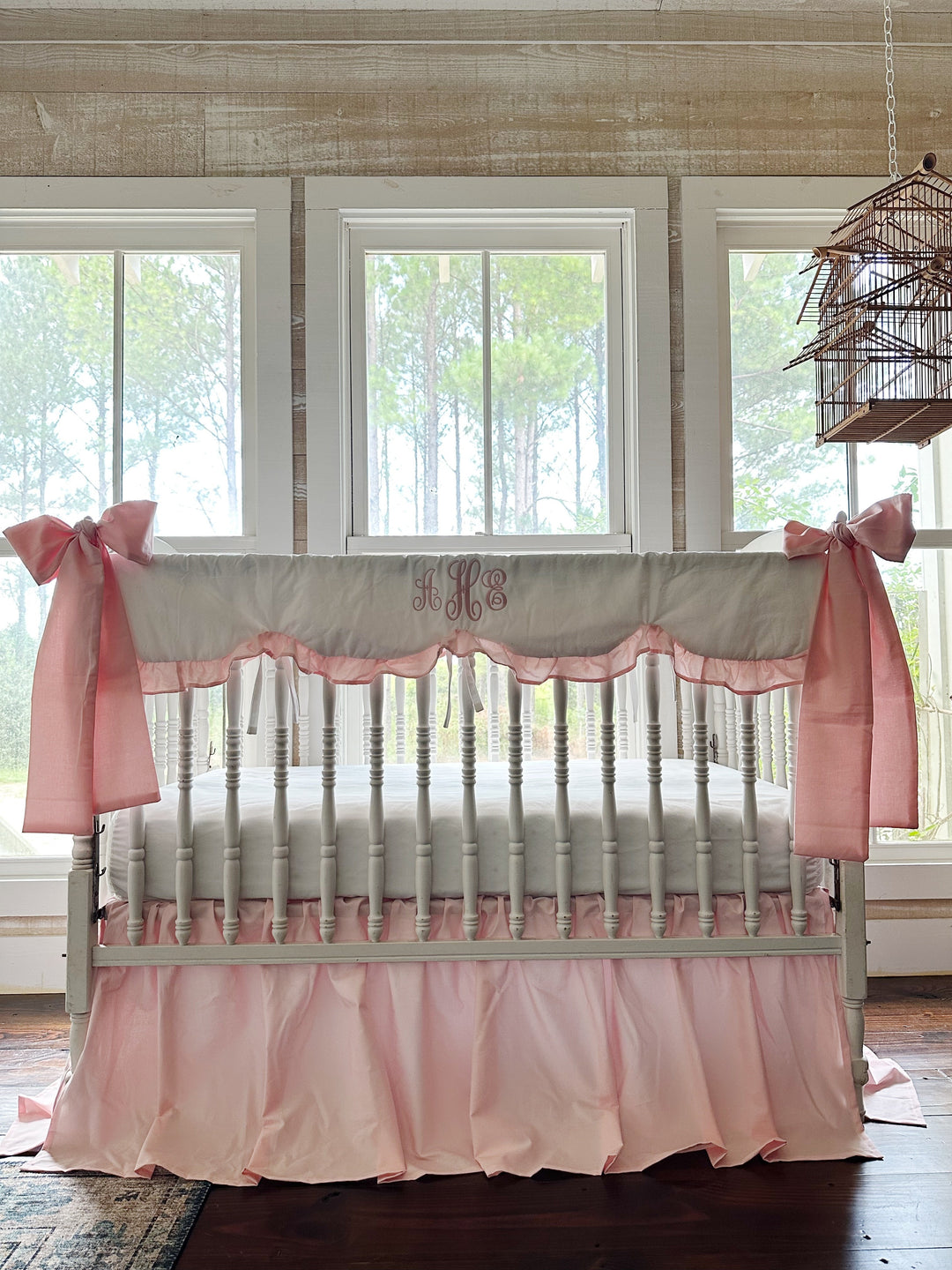 Personalized Sisters Pink crib bedding set styled on a white spindle crib in a farmhouse nursery