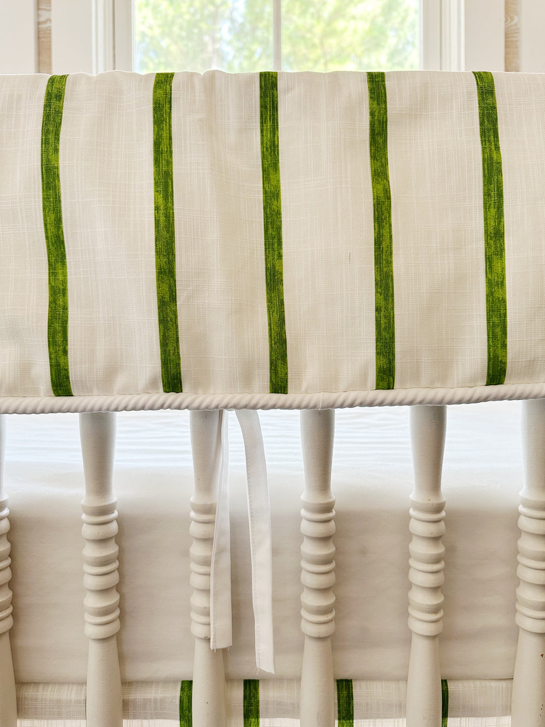 Close view of the brushed green stripes on textured white cotton, the white cording edge and a slim white tie