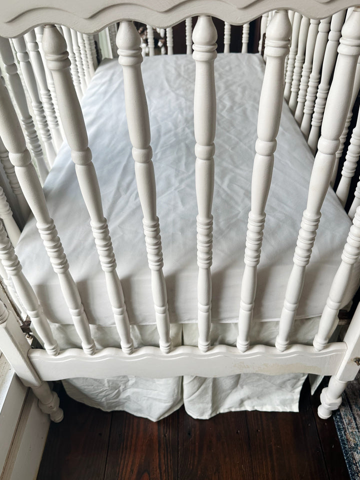 Looking down into the crib at the porcelain skirt hanging beneath the mattress deck - High Cotton Textile