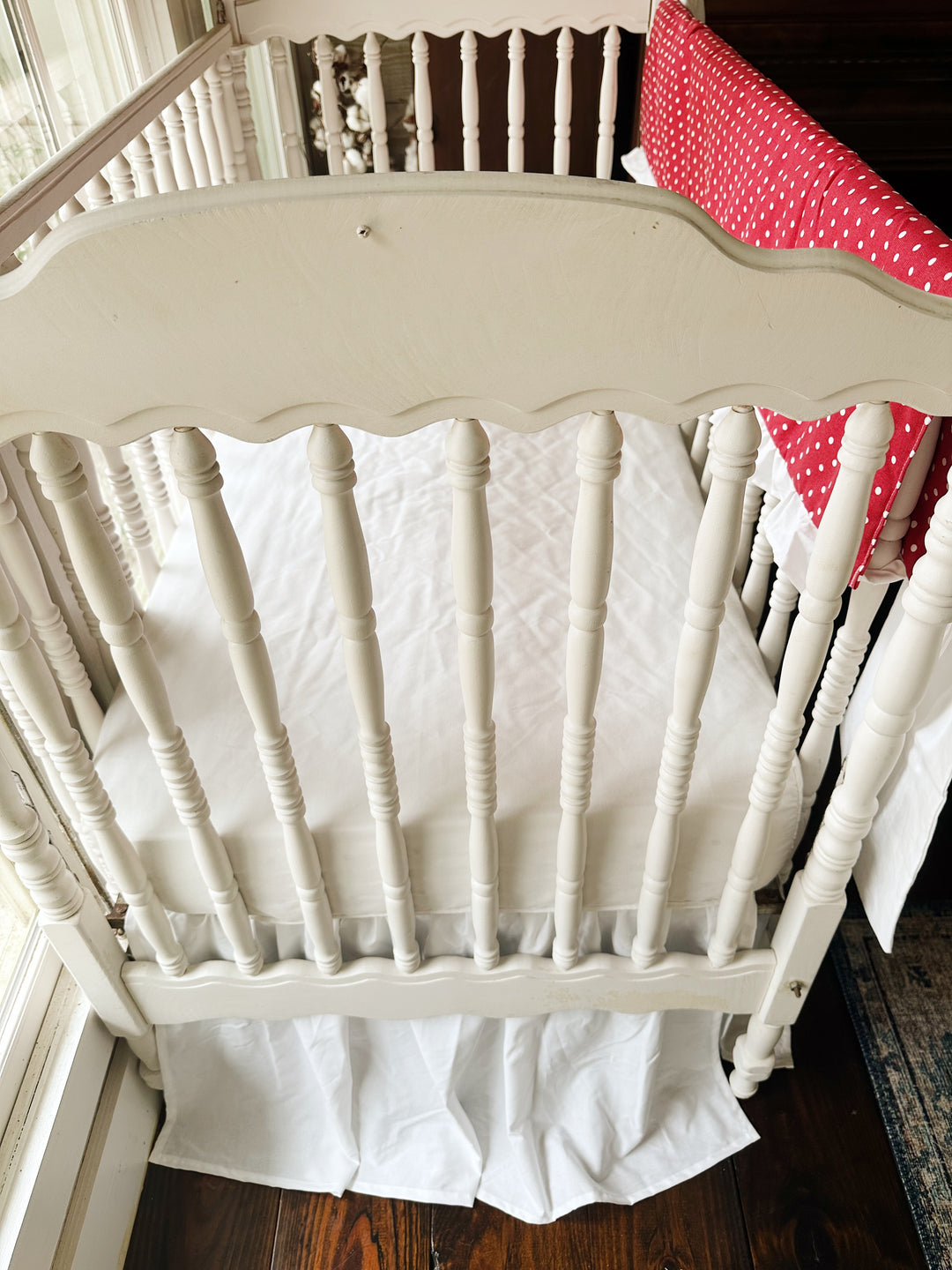 Foot of the crib with the white farmhouse skirt at a 20-inch drop