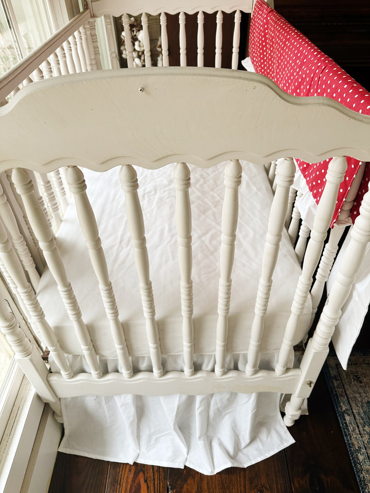 Foot of the crib with the white farmhouse skirt at a 20-inch drop