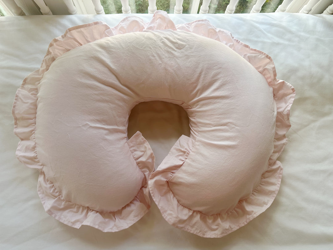 Front view of the Baby Pink nursing pillow cover with its gathered ruffle flouncing around both tips