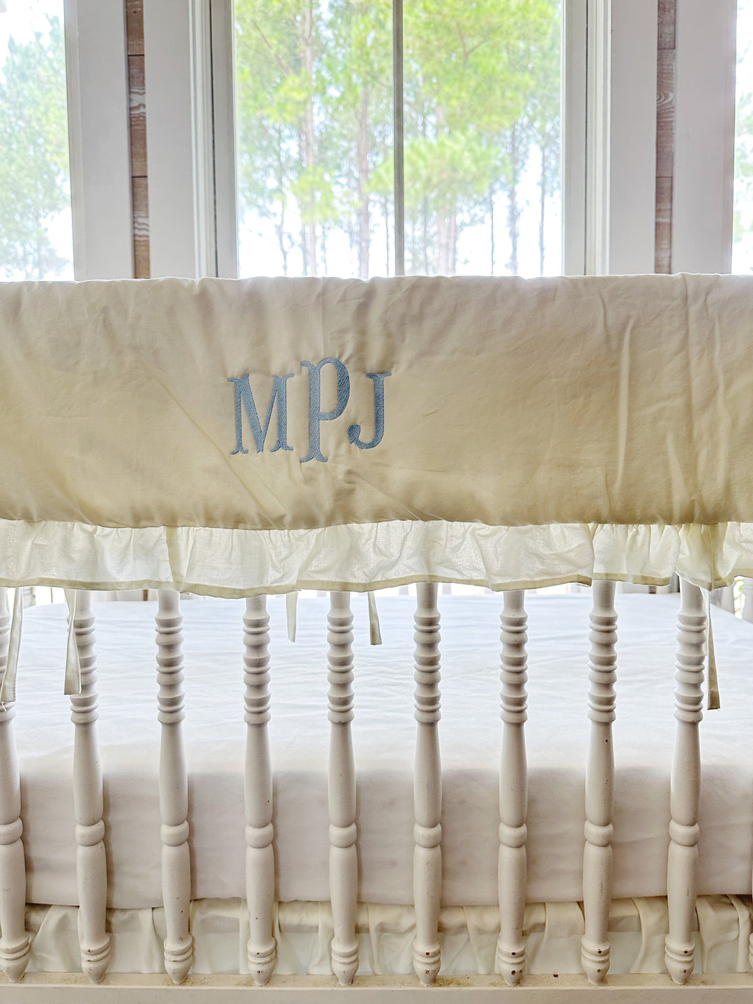 Blue monogram embroidered on the porcelain rail cover above the ruffled edge