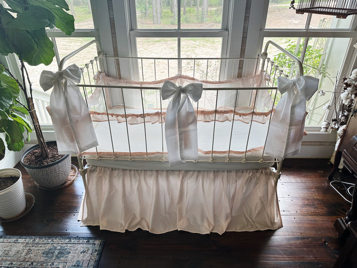 White large crib bow tied around crib railing