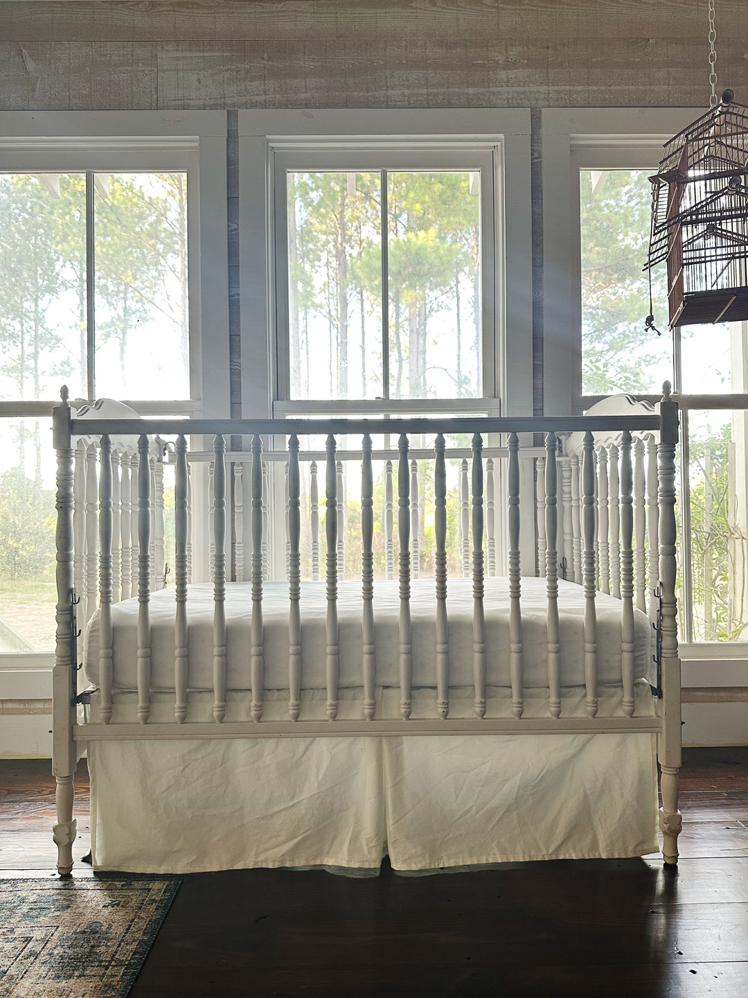 Porcelain tailored cotton crib skirt on a white spindle crib, straight on from the foot - High Cotton Textile