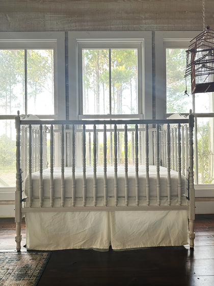 Porcelain tailored cotton crib skirt on a white spindle crib, straight on from the foot - High Cotton Textile