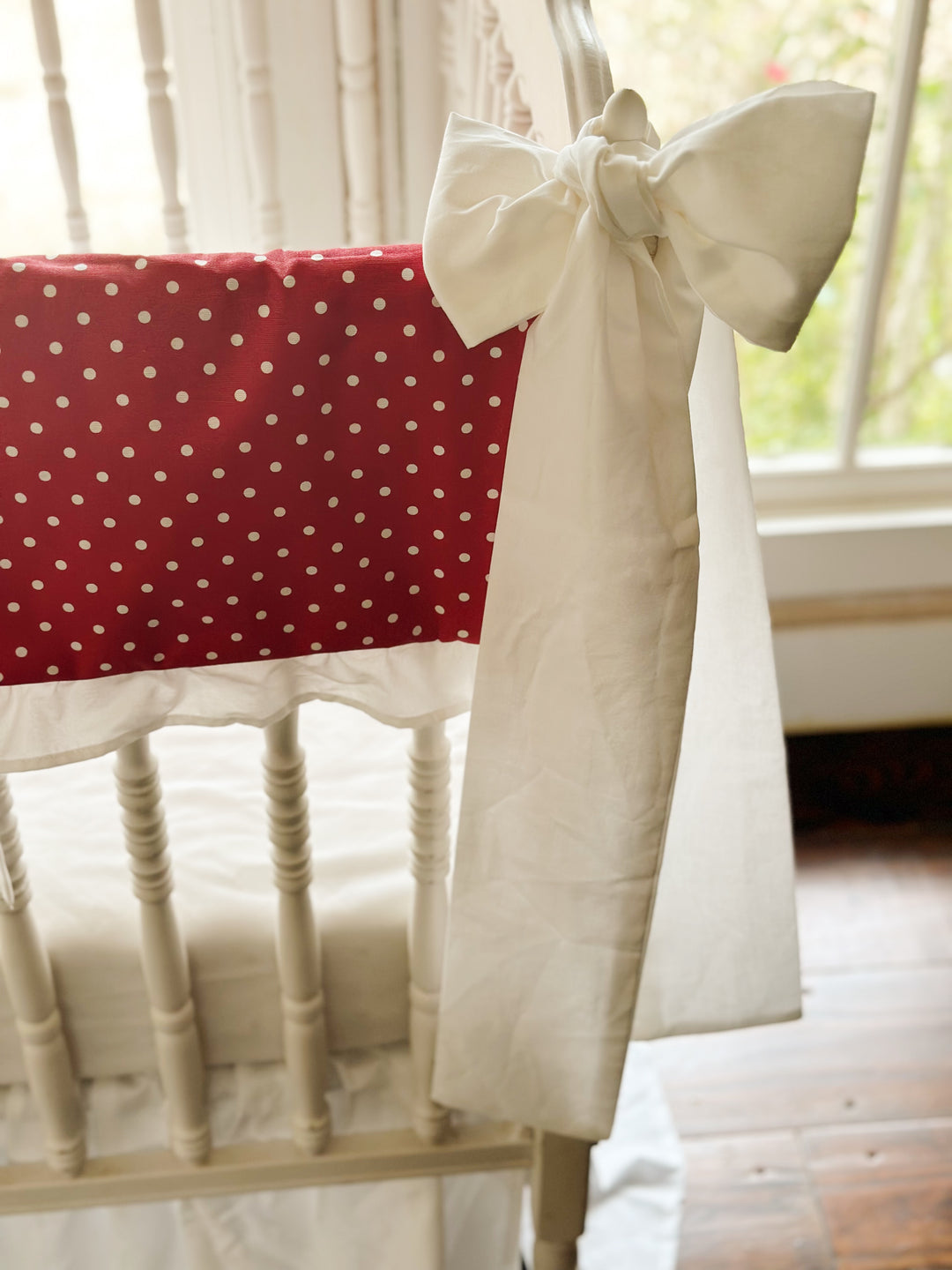 The red polka dot panel meeting a white sash, its tails falling toward the floor