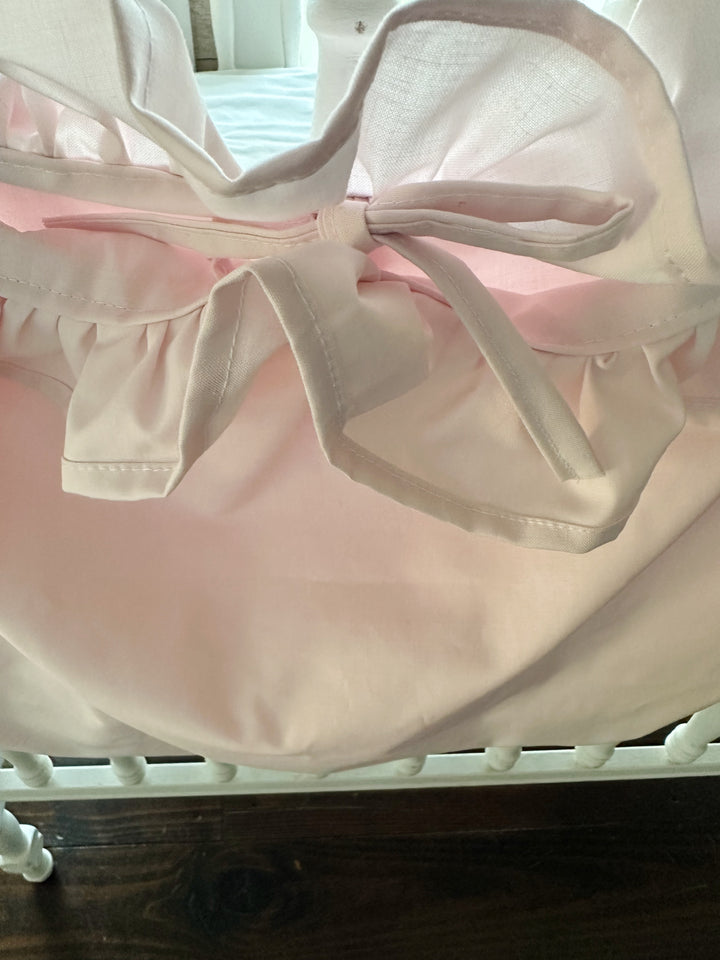 Center tie bow and gathered ruffle at the top of the baby pink cotton caddy