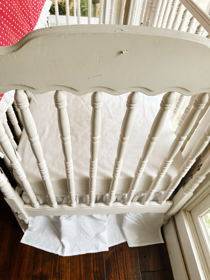 Foot of the crib with the white farmhouse skirt at a 20-inch drop