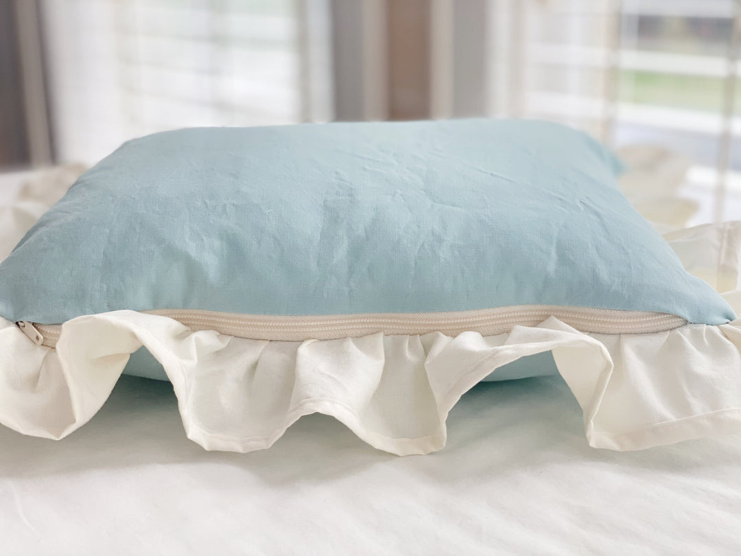 Side view of the mist crib pillow showing the zipper and ruffle depth