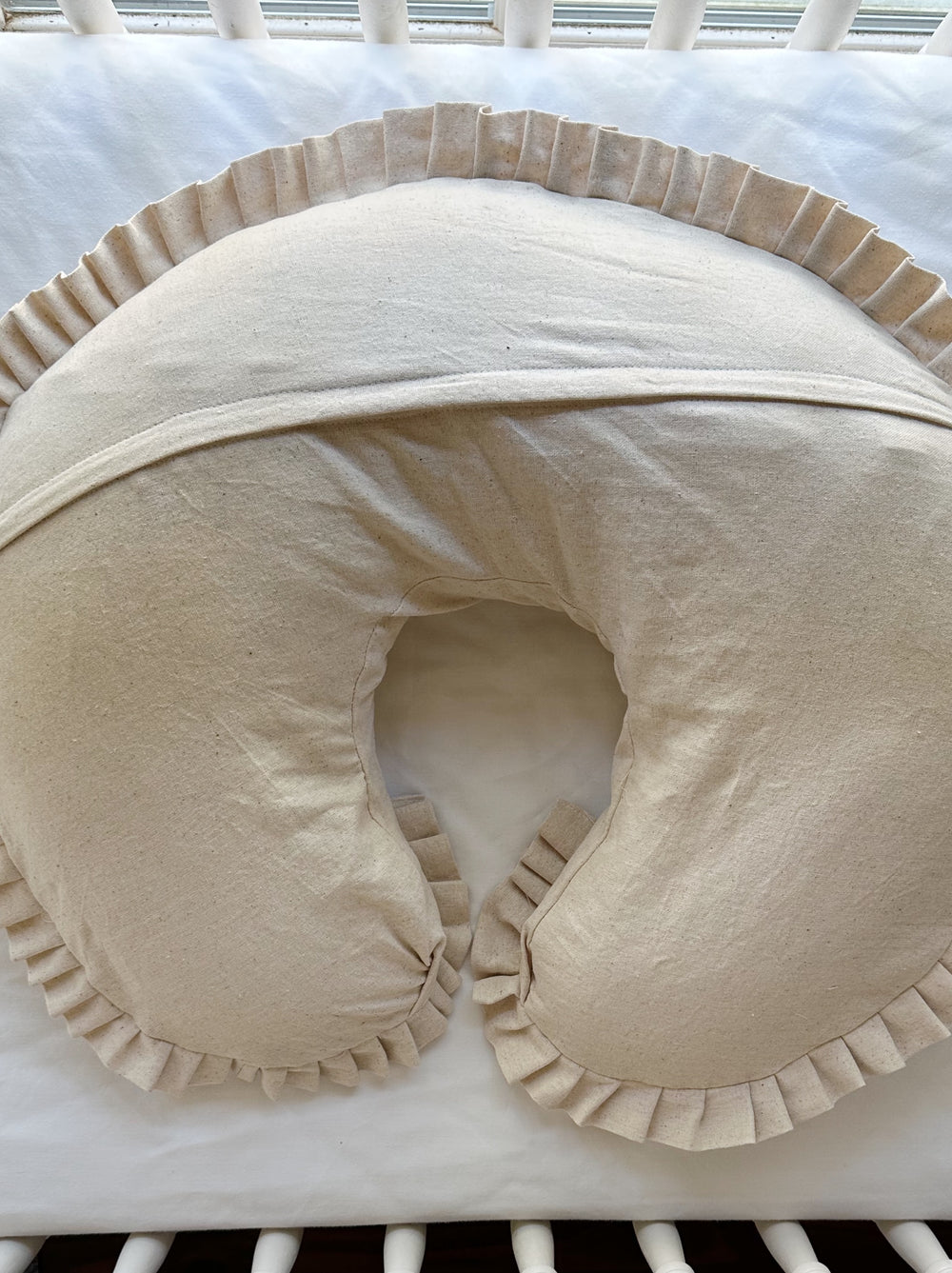 Back of the Natural Osnaburg Boppy pillow cover showing the envelope flap across the curve and the pleated ruffle edge