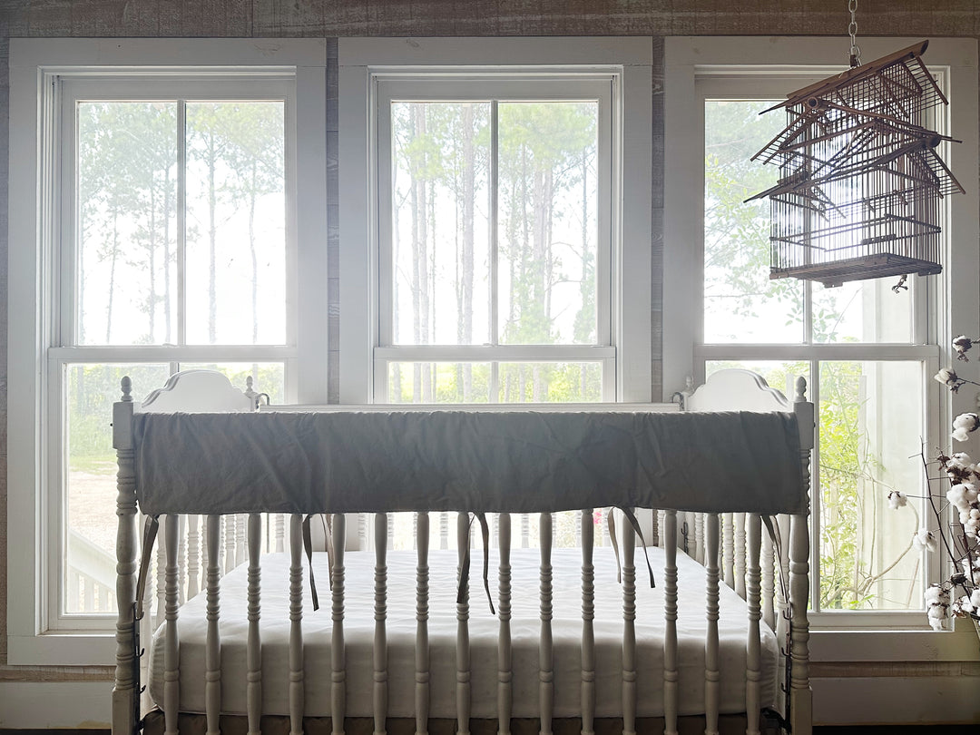 Gender neutral oatmeal crib rail cover styled on white crib in sunlit farmhouse nursery - High Cotton Textile