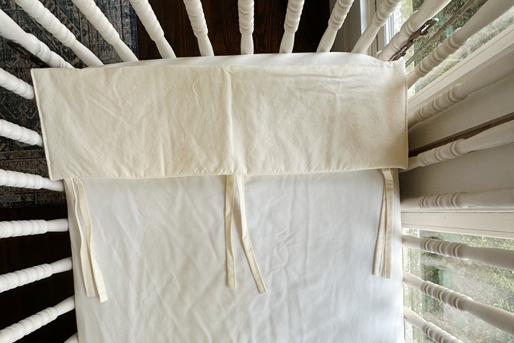 Detail of the ivory rail cover folded open to show the stitched edge and tie placement