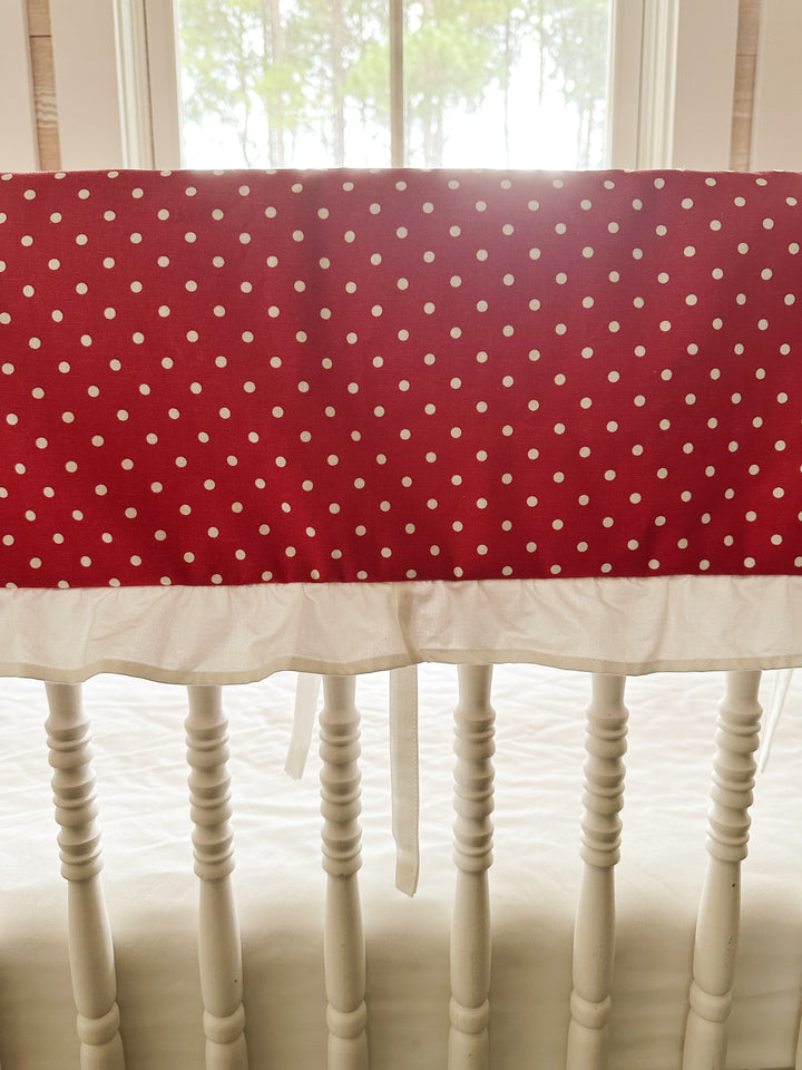 Close view of the small white dots on deep cherry red cotton above the gathered white ruffle