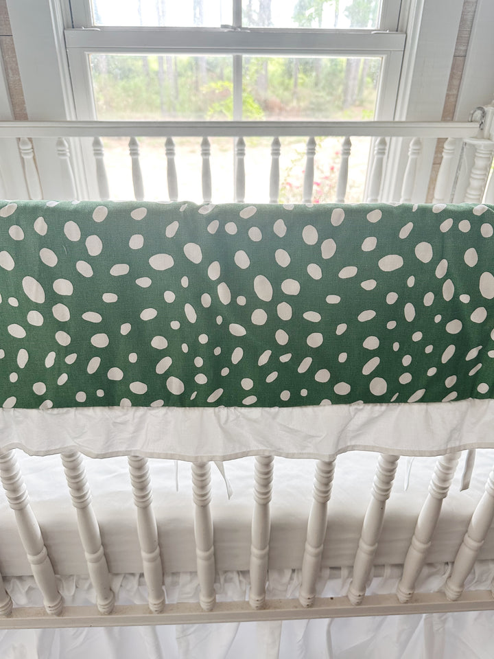 Close view of the irregular white spots on deep green cotton above the gathered white ruffle