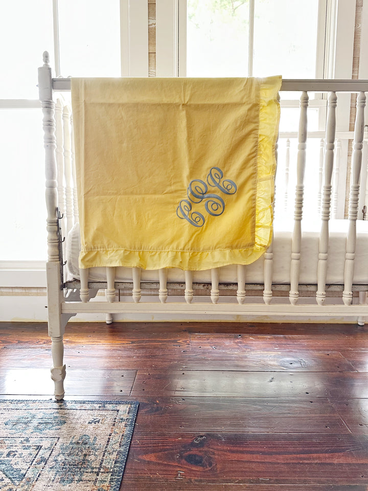 Gender neutral baby yellow ruffled crib blanket styled on a white crib in a farmhouse nursery - High Cotton Textile