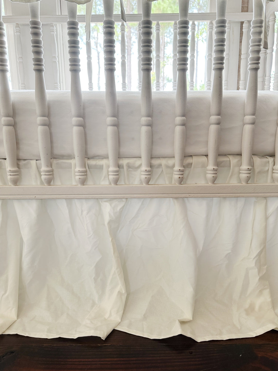Close view of the double ruffle where the rail cover meets the crib spindles