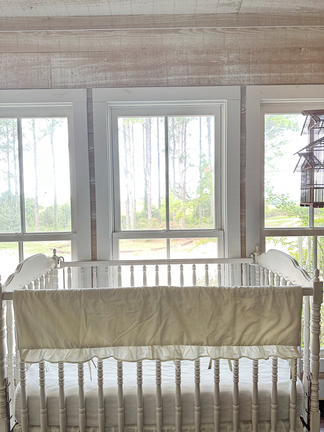 Porcelain rail cover without monogram draped over the crib rail beneath bright windows