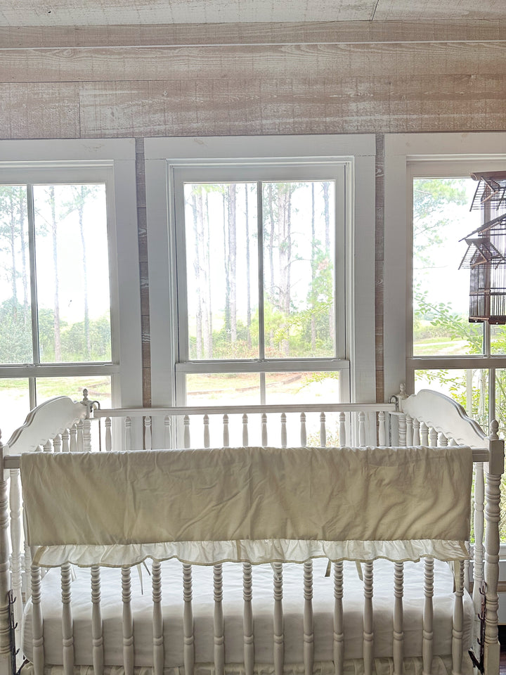 Porcelain rail cover without monogram draped over the crib rail beneath bright windows