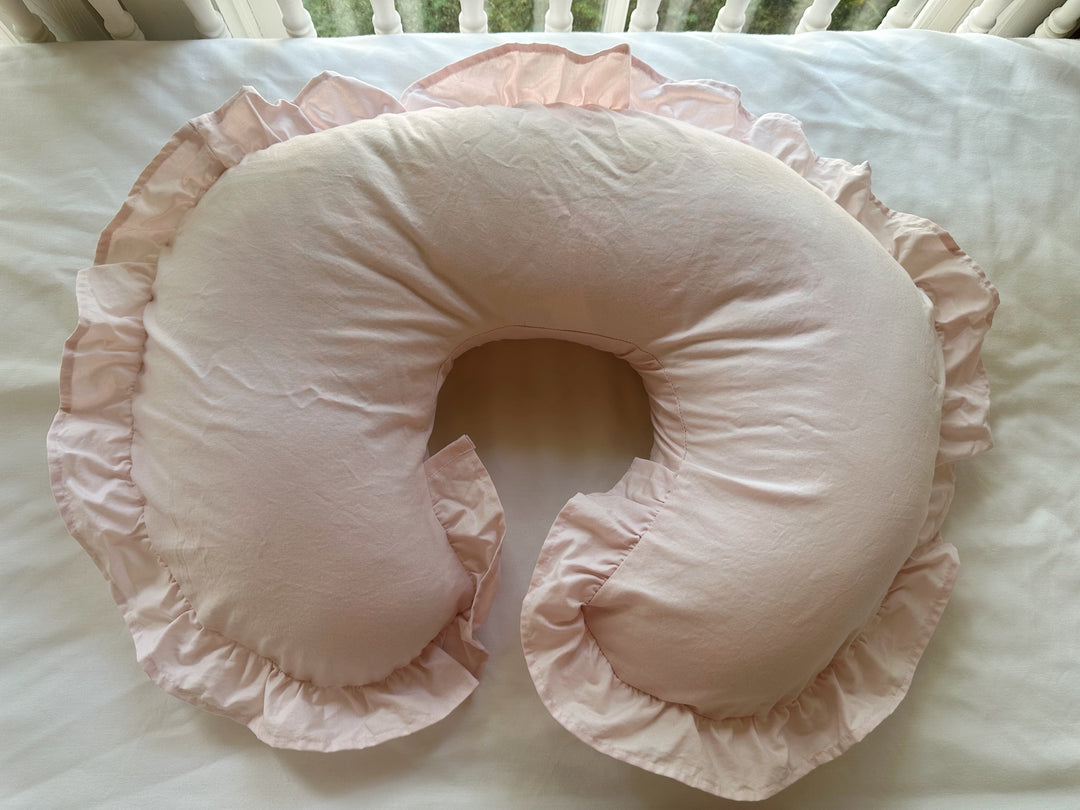 Baby Pink ruffled Boppy pillow cover with a full gathered ruffle, laid on a white crib mattress - High Cotton Textile