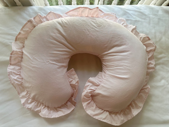 Baby Pink ruffled Boppy pillow cover with a full gathered ruffle, laid on a white crib mattress - High Cotton Textile