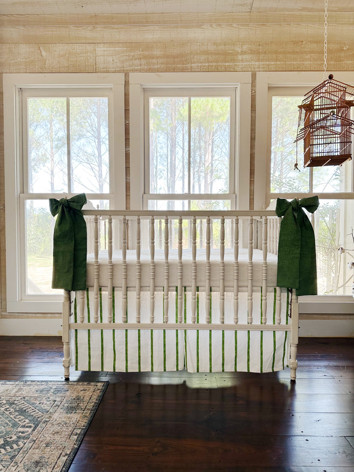 The striped skirt and green sashes across a pine-paneled room with three windows and a hanging birdcage