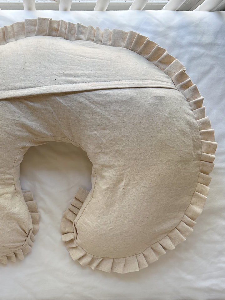 Close view of one side of the Natural Osnaburg nursing pillow cover, pleated ruffle following the outer curve to the tip