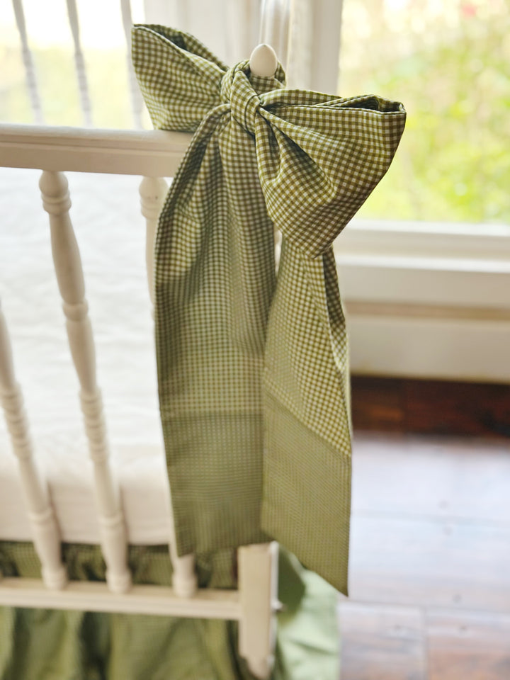 Large pine green gingham crib bow hand-tied to a white crib post