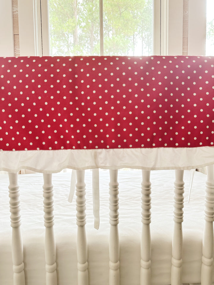 Close view of the small white dots on deep cherry red cotton above the gathered white ruffle