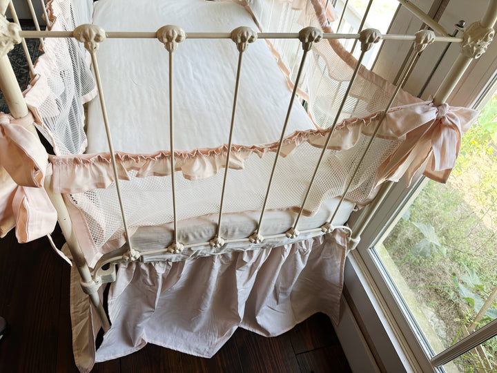 Close-up of crib skirt gathered detailing and split corners, 20-inch drop, ballet slipper pink