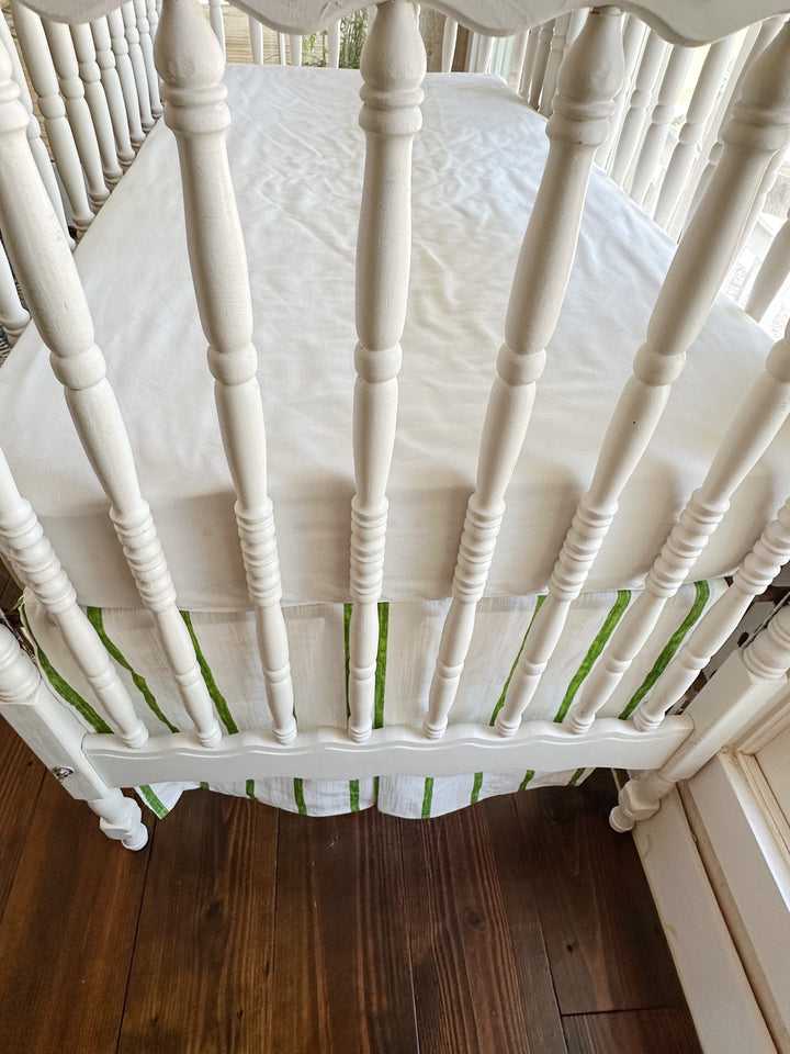 Close view of the striped skirt and its center pleat between the turned spindles