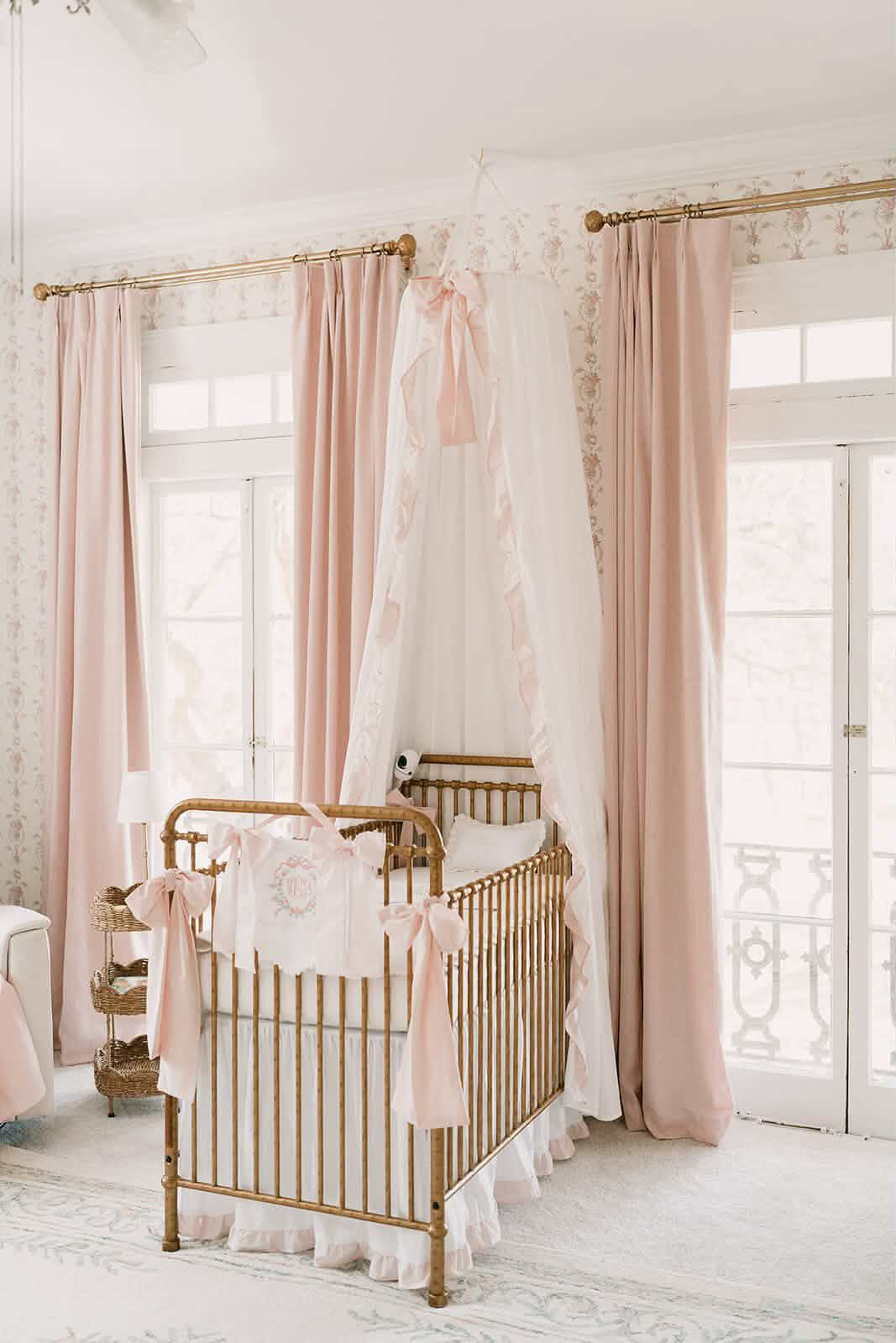 White and baby pink ruffled crib canopy hanging over gold crib in pink and white nursery - High Cotton Textile