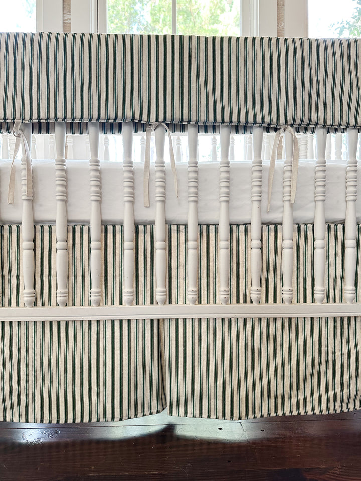 Close view of the plain ticking rail cover, its narrow natural osnaburg ties, and the striped skirt below the spindles