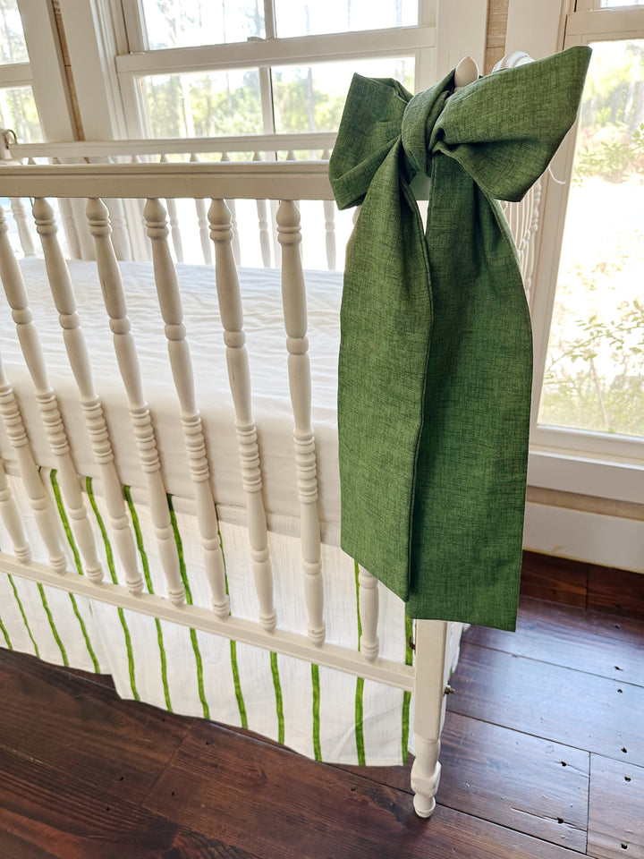 Side view of a green sash at the rail with the striped skirt and its pleat below