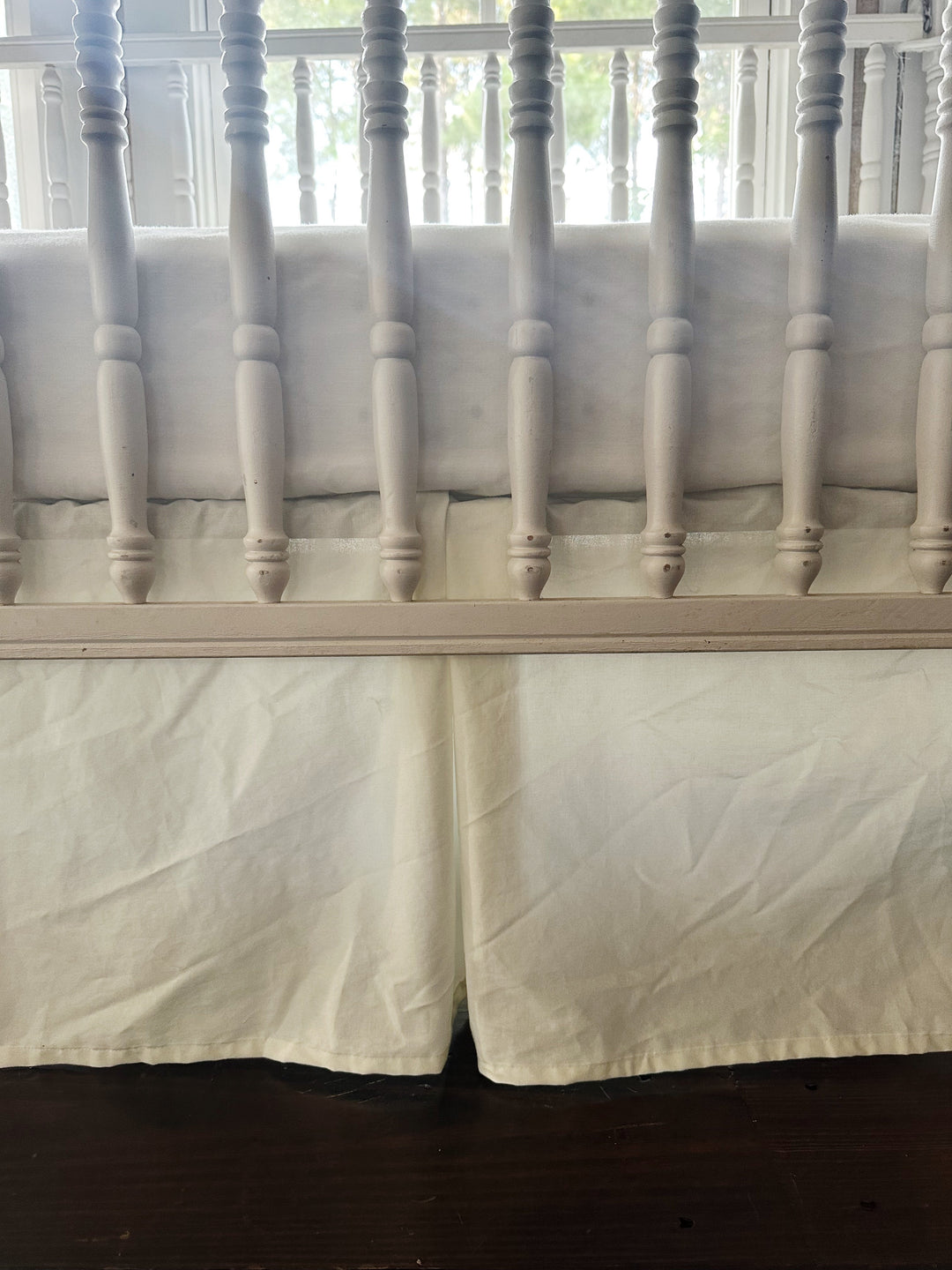 Close up of the flat pleated panel and center split on the porcelain washed cotton crib skirt - High Cotton Textile