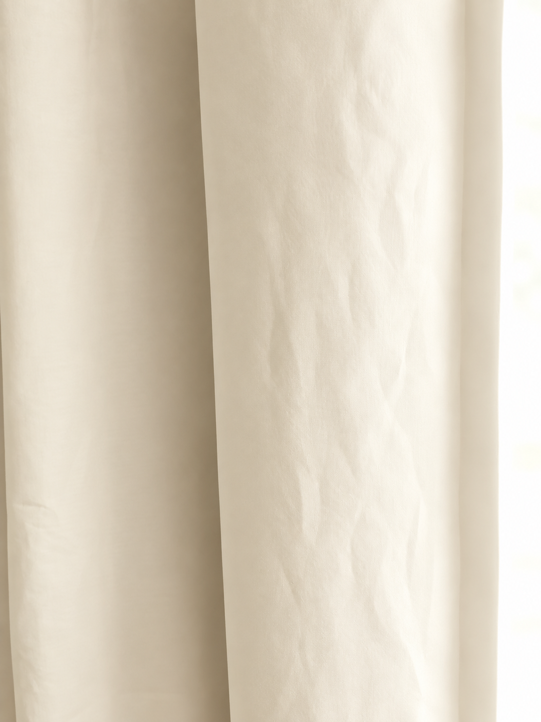 Close view of soft ivory washed cotton, showing the weave and the gentle fold of the panel