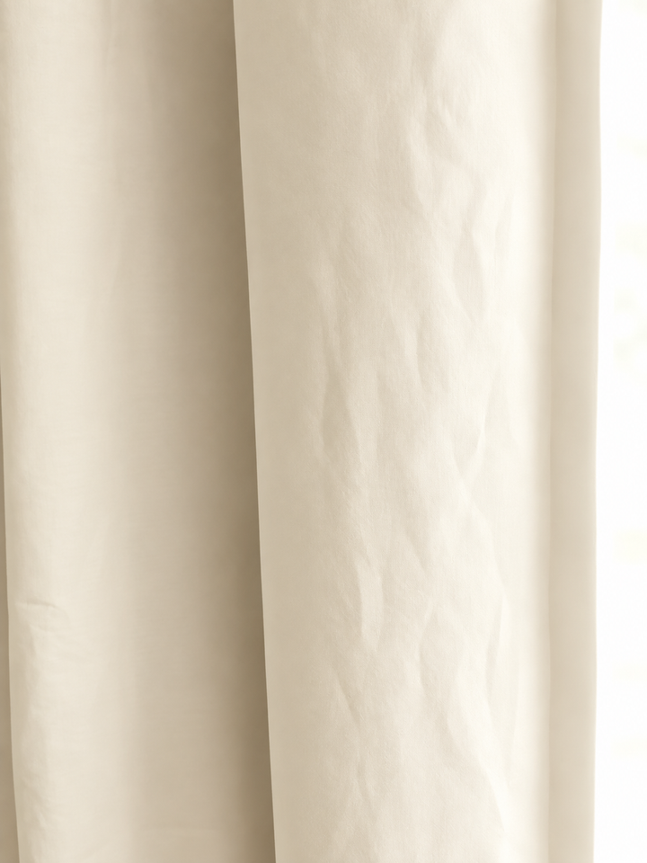 Close view of soft ivory washed cotton, showing the weave and the gentle fold of the panel