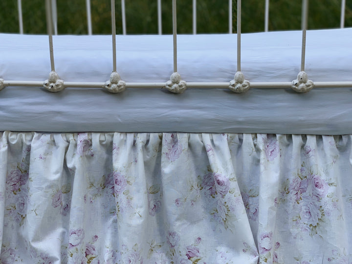 Gathered lavender floral crib skirt overhead view showing 4-sided coverage and split corners