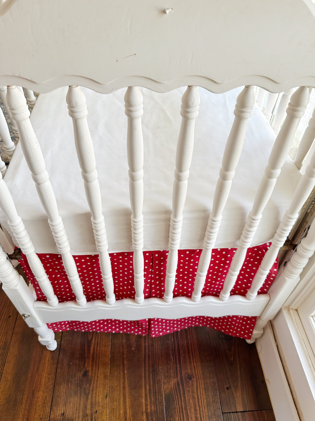 Close on the skirt's inverted center pleat where the two dotted panels meet below the scalloped end panel