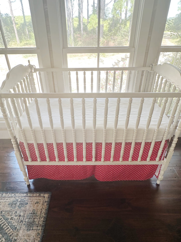 Slightly elevated view of the crib with the dotted skirt hanging to the floor