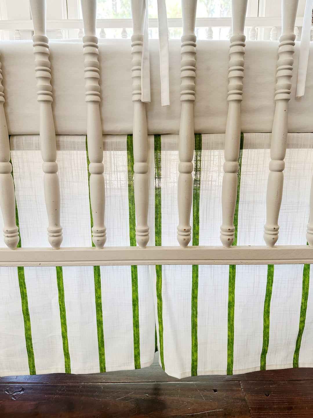 The tailored skirt's corner pleat and green stripes seen between the turned spindles