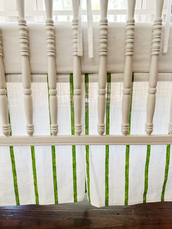 The tailored skirt's corner pleat and green stripes seen between the turned spindles