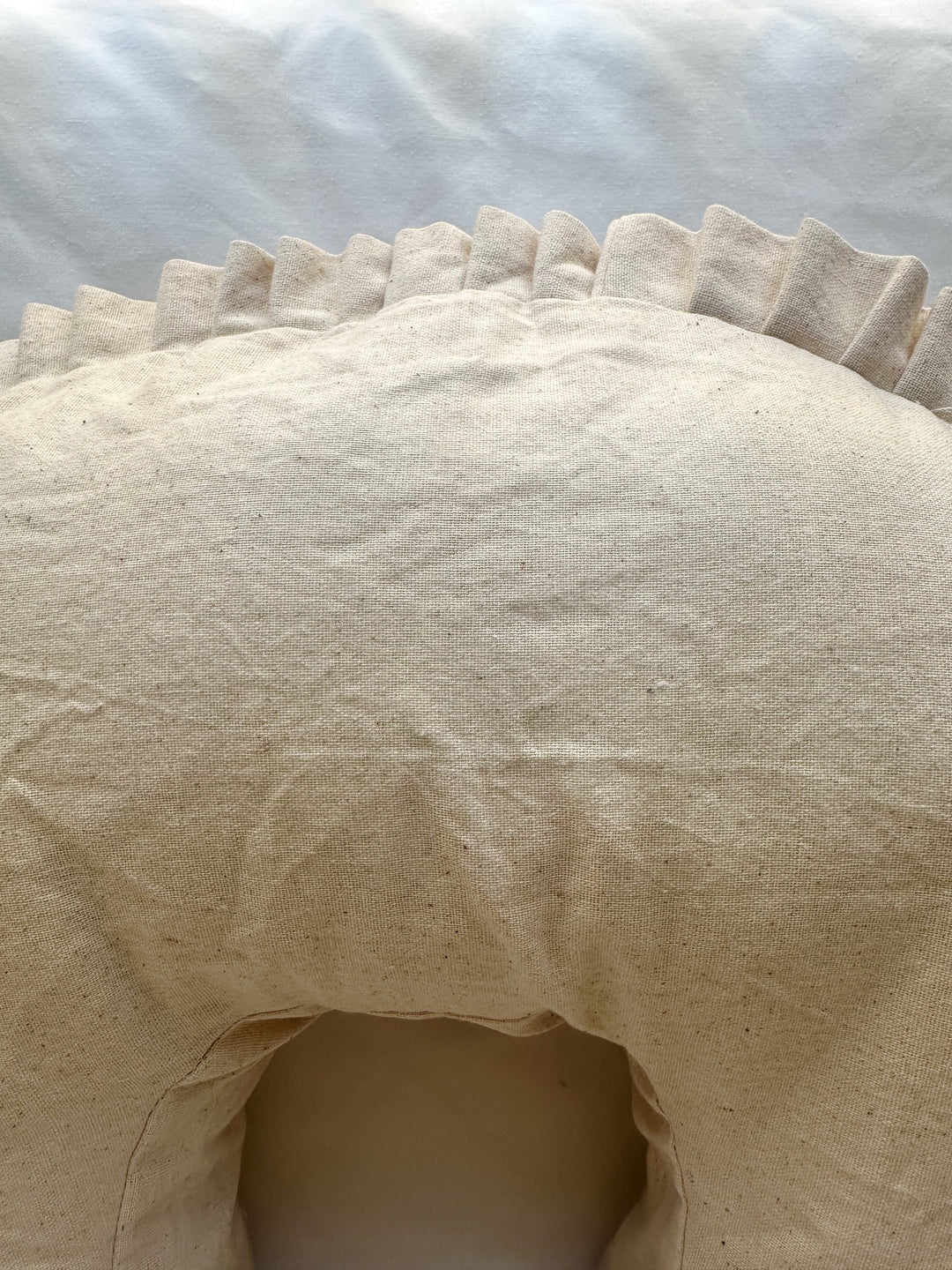 Top of the Natural Osnaburg nursing pillow cover above the inner curve, with the pleated ruffle along the back edge