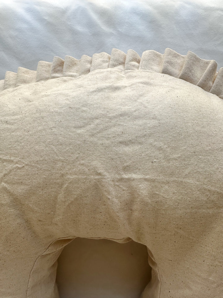 Top of the Natural Osnaburg nursing pillow cover above the inner curve, with the pleated ruffle along the back edge
