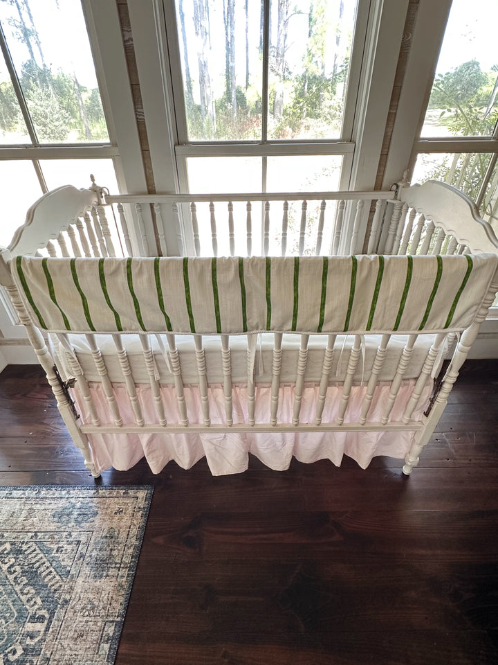 Overhead view of the whole crib showing the green stripe above the gathered pink skirt